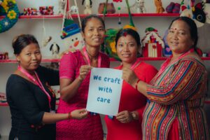 Photo of our artisans with sign saying 'We craft with care'